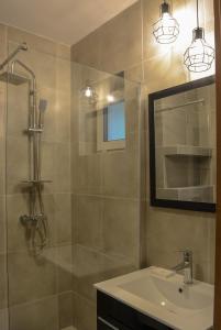 a bathroom with a shower and a sink and a mirror at Apartamenty Asturia in Rymanów-Zdrój