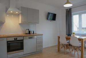 a kitchen with a table and a dining room at Apartamenty Asturia in Rymanów-Zdrój