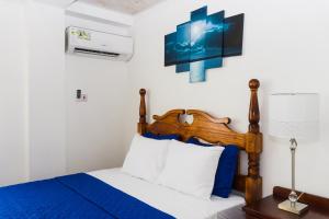 a bedroom with a bed with blue and white sheets at Calliandras Apartment Complex in Kingstown