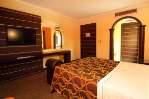 a hotel room with a bed and a flat screen tv at Motel Mirage in Guadalajara