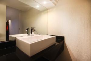 a bathroom with a white sink and a mirror at Motel Mirage in Guadalajara