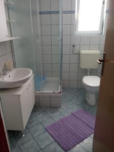 łazienka z umywalką, toaletą i prysznicem w obiekcie Apartmani Ana Vir w mieście Vir