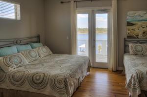 a bedroom with two beds and a sliding glass door at Seaspray in Santa Rosa Beach +52 photos