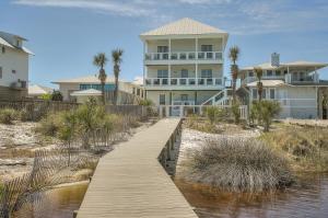 a house on the beach with a wooden walkway to the water at Seaspray in Santa Rosa Beach