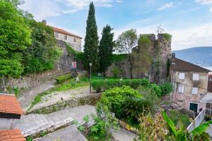 an old stone wall with trees and plants at Central, Quiet & Romantic Apartment in Herceg-Novi +11 photos