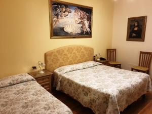 a bedroom with two beds and a painting on the wall at Hotel La Rosa in Ronta