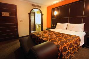 a hotel room with a bed and a chair at Motel Mirage in Guadalajara +3 photos