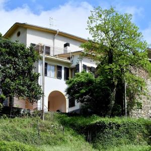 une maison blanche avec un arbre en face dans l'établissement Il Villino, à San Colombano Certenoli