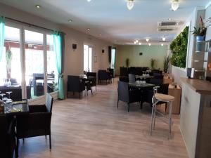 a dining room with tables and chairs in a restaurant at Domaine de l'Albatros in Mouans-Sartoux