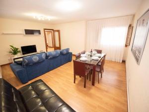 a living room with a blue couch and a table at Espacios Blanco Plaza del Viejo Coso in Valladolid