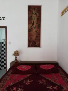 - une chambre avec un lit doté d'un tapis rouge dans l'établissement Lia Homestay, à Yogyakarta