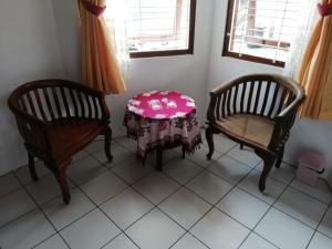 a room with two chairs and a table with a table cloth at Lia Homestay in Yogyakarta +12 photos