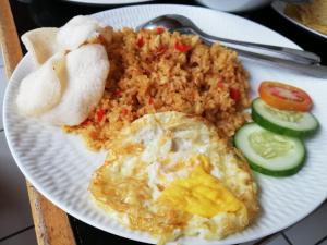 a plate of food with eggs and rice and vegetables at Lia Homestay in Yogyakarta