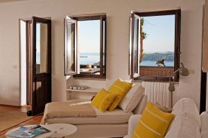 a living room with a couch and two windows at Il Chiostrino in Gardone Riviera
