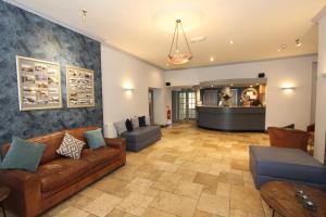 sala de estar con sofá, sillas y bar en Gwesty Nanhoron Arms Hotel, en Nefyn