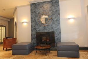 a living room with a fireplace and two stools at Gwesty Nanhoron Arms Hotel in Nefyn