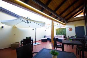 un patio con tavoli, sedie e ombrellone di Guest House Capitan Libeccio a Tropea