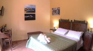 um quarto com uma cama com uma boneca em Feudo Magazzeni Etna em SantʼAlfio