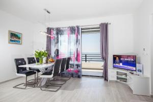 a dining room with a table and a television at Villa Matić in Makarska
