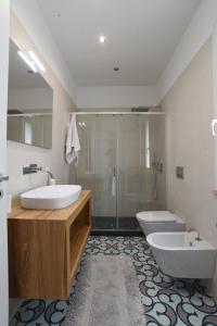 a bathroom with two sinks and a shower and a toilet at Casa Magnolia in Castelbuono