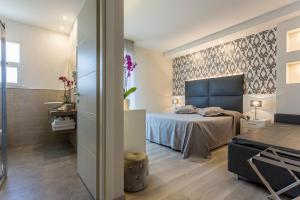 a bedroom with a blue bed and a bathroom at Hotel Riviera in Milano Marittima
