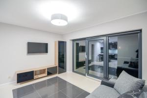 a living room with a couch and a tv at LIPOWA 6 in Piła