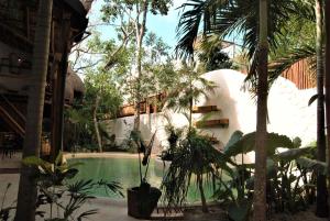 a pool in the middle of a resort with palm trees at Hotel Boutique TerraNova in Tulum