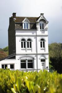 uma casa branca alta com um telhado em Liotte'sCorner Guesthouse em Sprimont