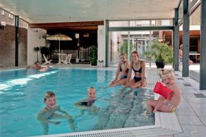 eine Gruppe von Kindern, die in einem Pool sitzen in der Unterkunft Marx Motel in Valkenburg