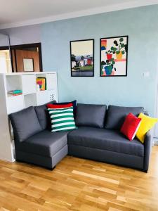 salon z niebieską kanapą i kolorowymi poduszkami w obiekcie Słoneczne Skorosze w Warszawie