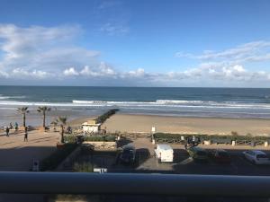 a view of the beach and the ocean from a balcony at LACANAU FRONT DE MER in Lacanau