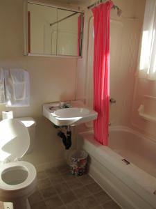a bathroom with a toilet and a sink and a shower at Shine Motel in Summerside