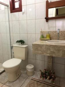 a bathroom with a toilet and a sink at Hospedaria Aconchego in Santa Teresa