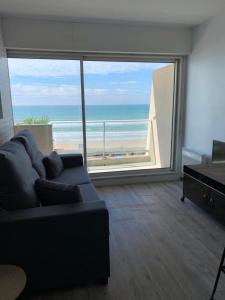 a living room with a couch and a view of the ocean at LACANAU FRONT DE MER in Lacanau