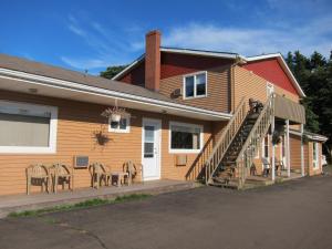 a house with a patio with chairs outside of it at Shine Motel in Summerside