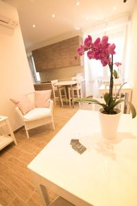 ein Wohnzimmer mit einem weißen Tisch und einer Pflanze darauf in der Unterkunft BePlace Aventino in Rom