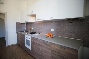 a kitchen with white cabinets and a bowl of fruit on the counter at Casa Viorica in Ancona +21 photos