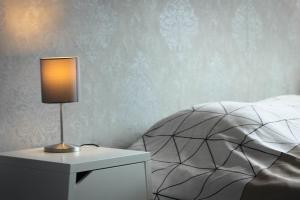 a lamp on a night stand next to a bed at Liotte'sCorner Guesthouse in Sprimont