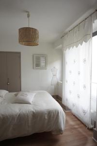 Château des Basses Roches في La Chaussée-Saint-Victor: غرفة نوم بيضاء بها سرير ونافذة