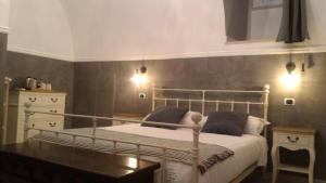 una camera con letto, tavolo e luci di Il Vicolo - Affittacamere a Ruvo di Puglia