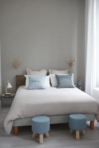 1 dormitorio con 1 cama grande y 2 taburetes azules en Château des Basses Roches, en La Chaussée-Saint-Victor
