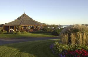 un grand bâtiment avec un toit sur une pelouse fleurie dans l'établissement Agaming Golf Resort, à Kewadin