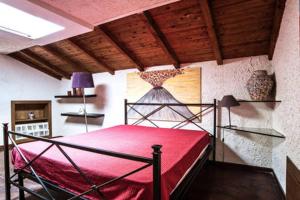 una camera con letto rosso di Casa Gisira a Catania