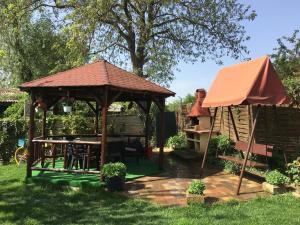 a gazebo with a table and a grill at Vila Tineretului in Satu Mare