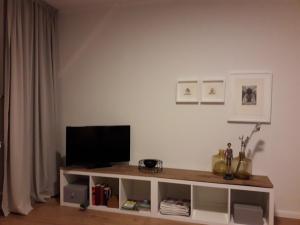 a living room with a flat screen tv on a shelf at Charmante, moderne Wohnung in Greven
