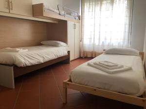 two beds in a small room with a window at Casa vacanze Filippo in San Siro