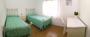 two beds in a room with a table and a desk at moonflower in Pliskovica