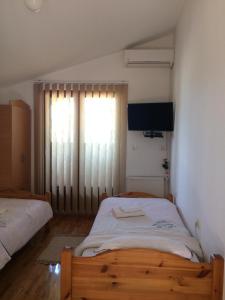sypialnia z 2 łóżkami pojedynczymi i oknem w obiekcie Guest House Jenić w mieście Golubac