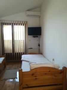 sypialnia z 2 łóżkami i dużym oknem w obiekcie Guest House Jenić w mieście Golubac