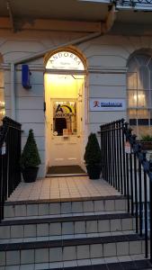 a white door of a building with two plants at Andorra Guest Accommodation in Brighton & Hove
